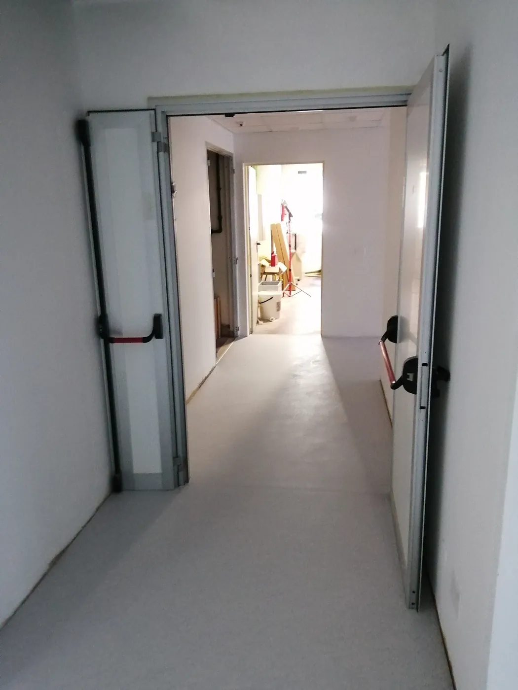 Porta a due ante con maniglioni antipanico, aperta sul corridoio